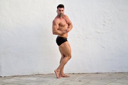 Pablo de cuerpo entero ante una pared blanca, en pose de preparación física.